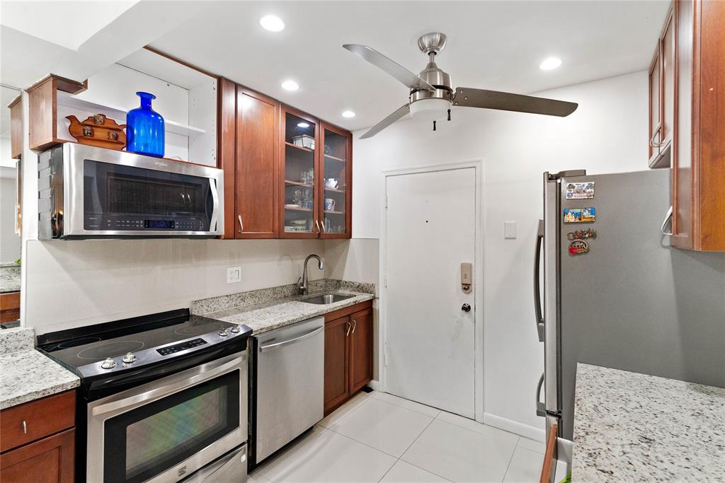 2151 Northeast 68th Street Fort Lauderdale, FL 33308 - Photo 13 of 45 a kitchen with stainless steel appliances granite countertop a refrigerator and a stove top oven