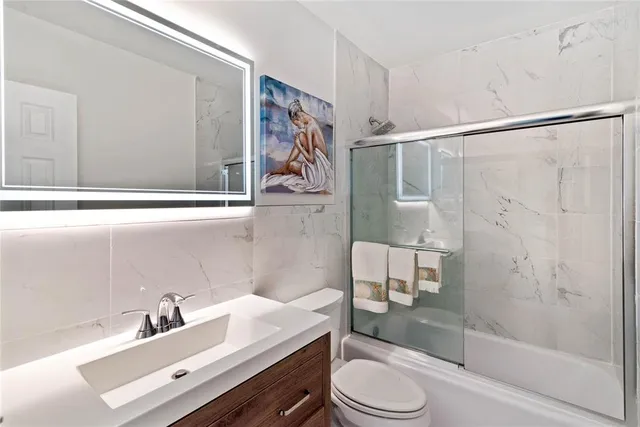 a bathroom with a sink toilet a mirror and shower