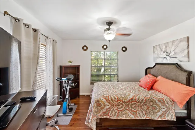 a bedroom with a bed and wooden floor