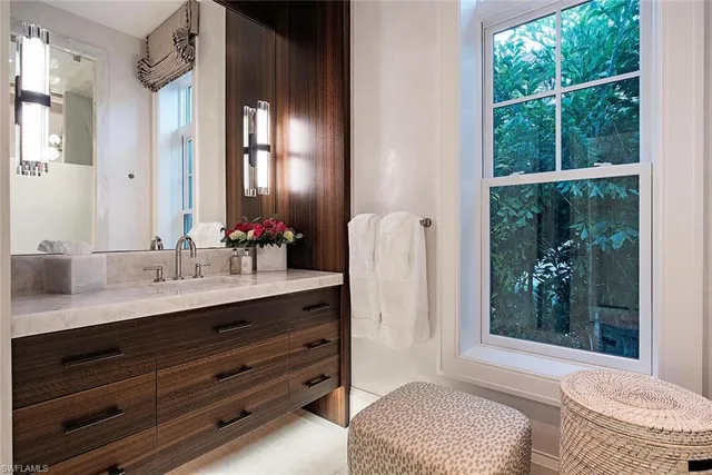 a bathroom with a granite countertop sink a large mirror and a bathtub