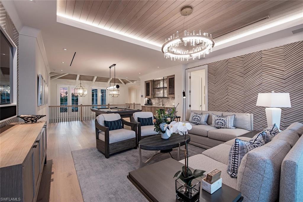 4115 Cutlass Lane Naples, FL 34102 - Photo 18 of 44 a living room with furniture a chandelier and a dining table