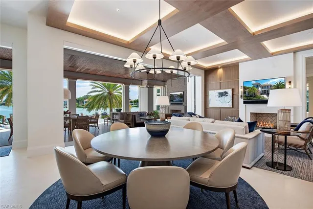 a dining room with wooden floor a chandelier a wooden table and chairs