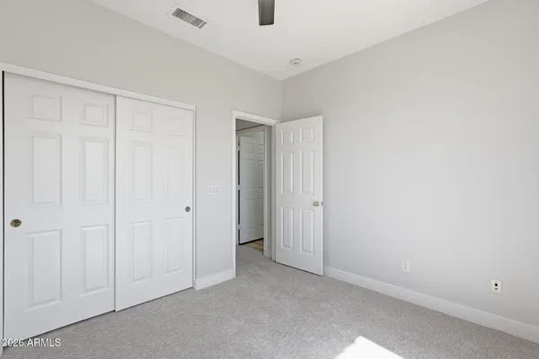 an empty room with a ceiling fan and window