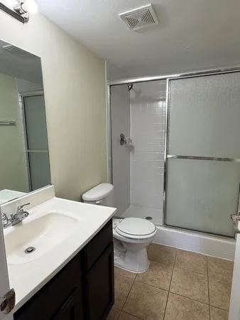 a bathroom with a sink a toilet a mirror and shower