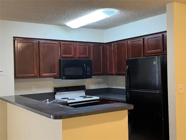 a kitchen with a refrigerator and a stove top oven