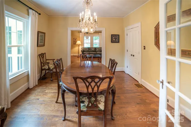 a dining room with furniture a chandelier and wooden floor