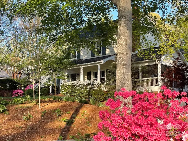 a front view of house with yard and trees around