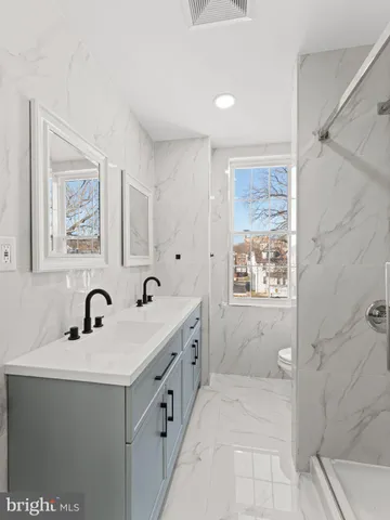 a bathroom with a double vanity sink a mirror and shower