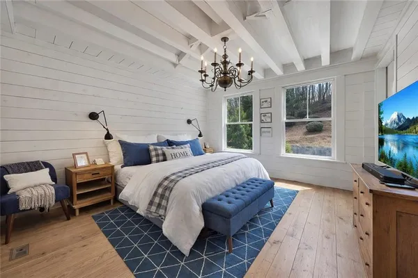 a bedroom with bed and wooden floor