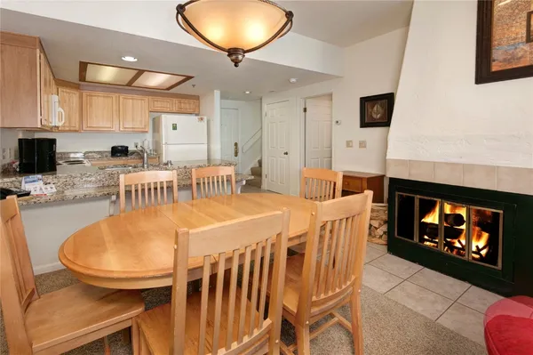 a dining room with furniture a fireplace and wooden floor