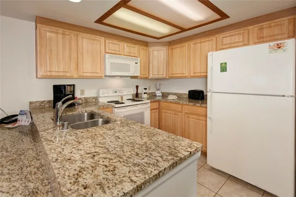 a kitchen with sink refrigerator and cabinets