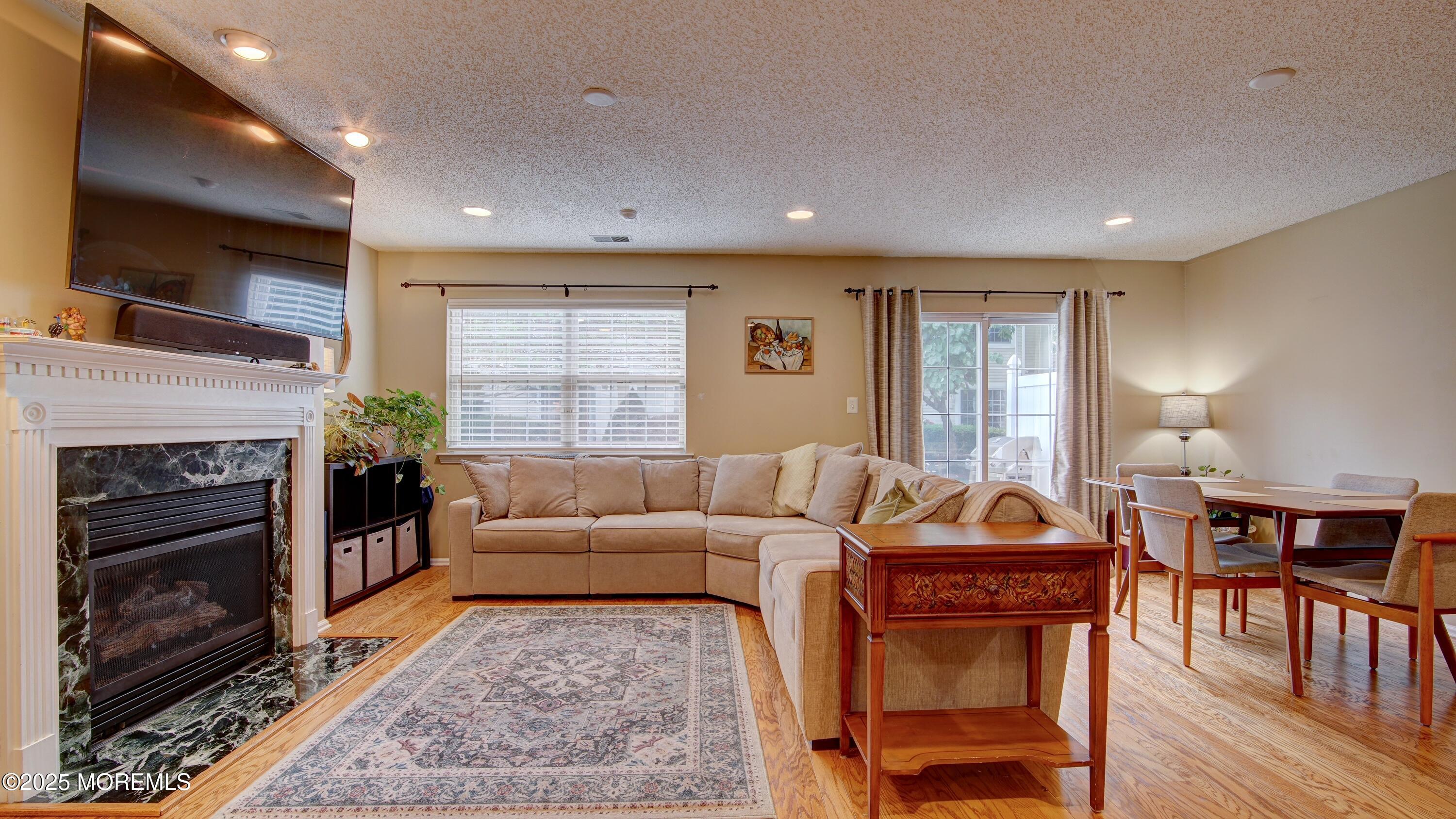 53 Winged Foot Court Howell, NJ 07731 - Photo 2 of 28 a living room with furniture flat screen tv and a fireplace