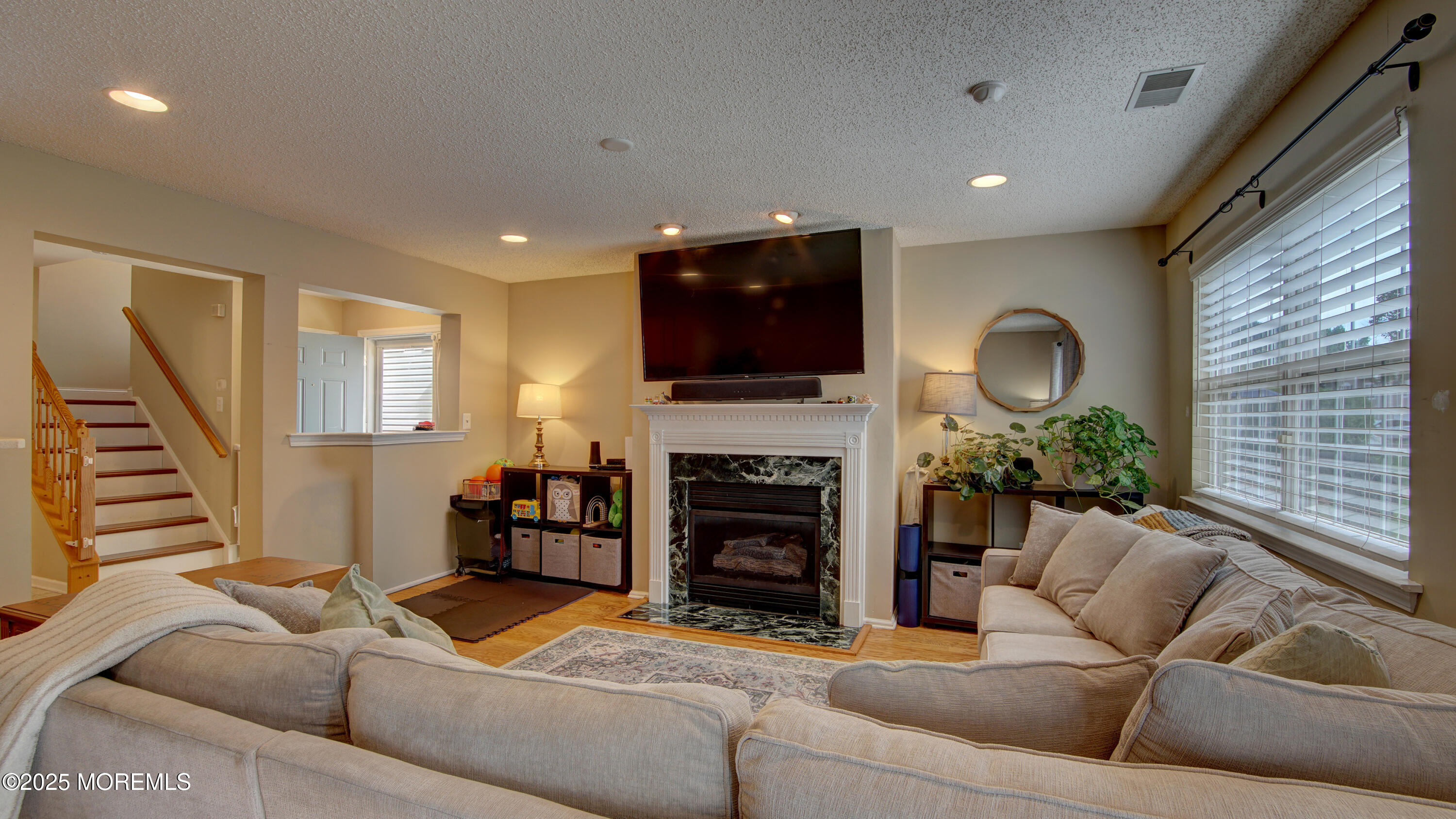53 Winged Foot Court Howell, NJ 07731 - Photo 4 of 28 a living room with furniture a fireplace and a flat screen tv