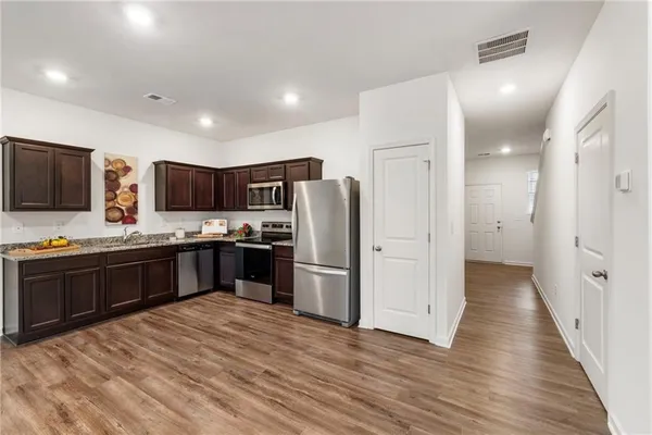 a large kitchen with a large counter top space stainless steel appliances and cabinets
