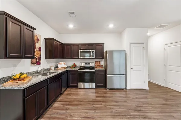 a kitchen with stainless steel appliances granite countertop a refrigerator and a stove top oven