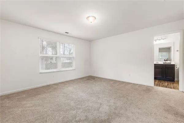 an empty room with windows and cabinet