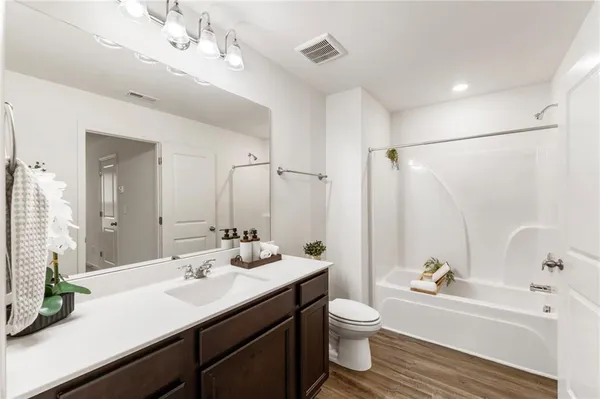 a bathroom with a tub a sink and mirror