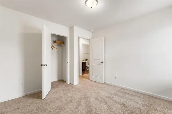 an empty room with closet and a bathroom