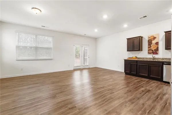a view of room with wooden floor and windows