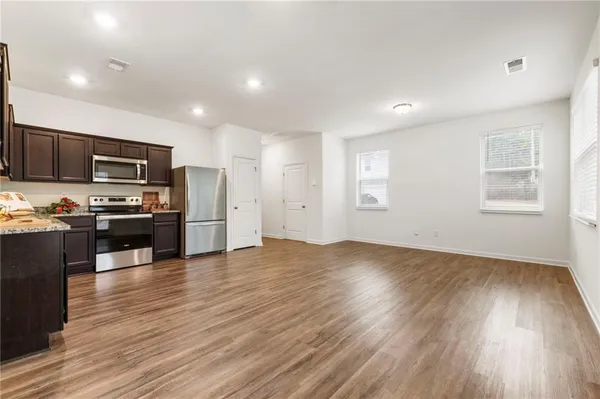 a view of kitchen with sink microwave refrigerator and cabinets