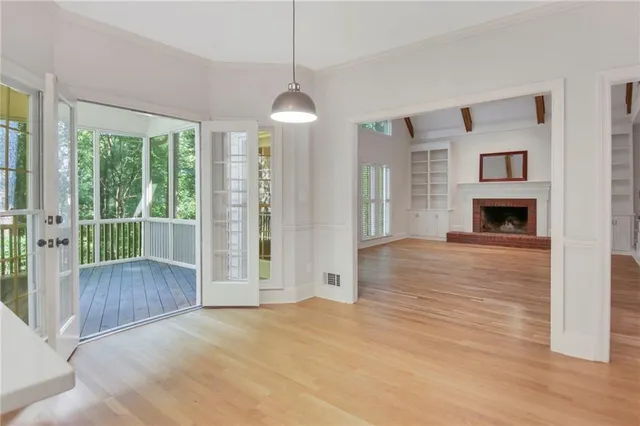 a view of empty room with wooden floor and fireplace