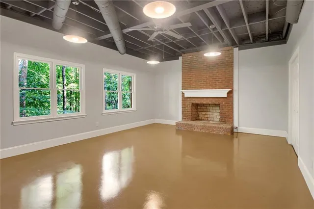 a view of an empty room with a fireplace and a window