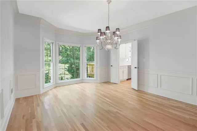 a view of a livingroom with a chandelier wooden floor and a chandelier