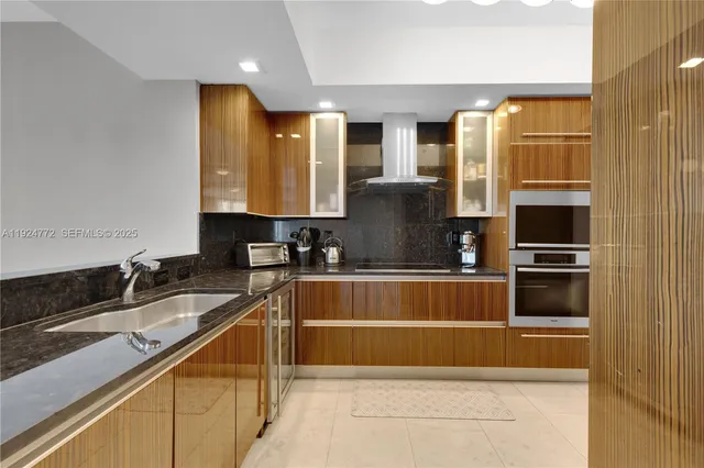 a kitchen with stainless steel appliances granite countertop a refrigerator and a stove
