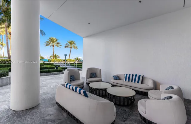 a living room with couches and kitchen view with wooden floor