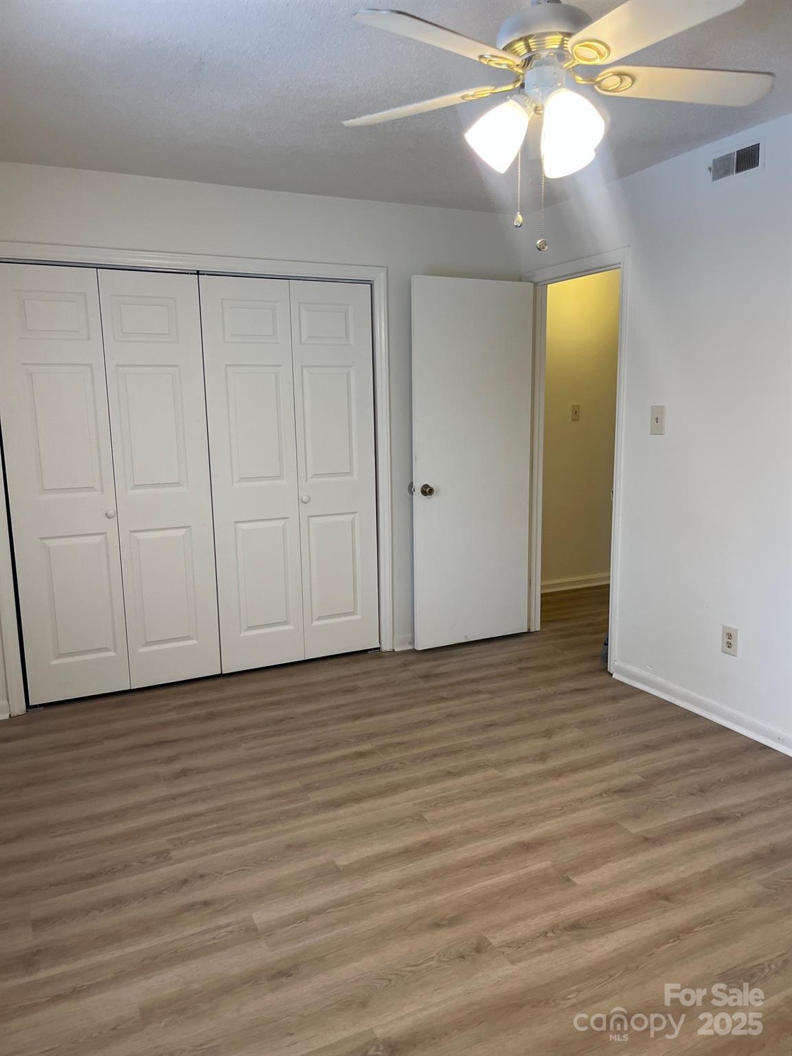 4520 Central Avenue, Unit C Charlotte, NC 28205 - Photo 6 of 18 a view of an empty room with wooden floor and a ceiling fan