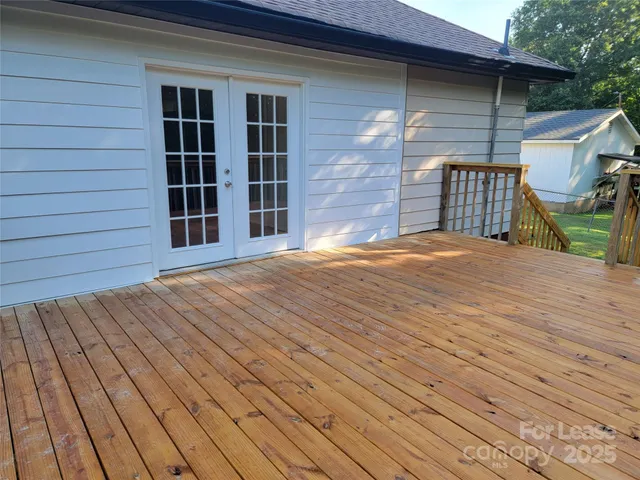 a view of a house with a barbeque and wooden stairs