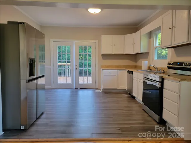 a kitchen with stainless steel appliances granite countertop a stove top oven a sink and a refrigerator