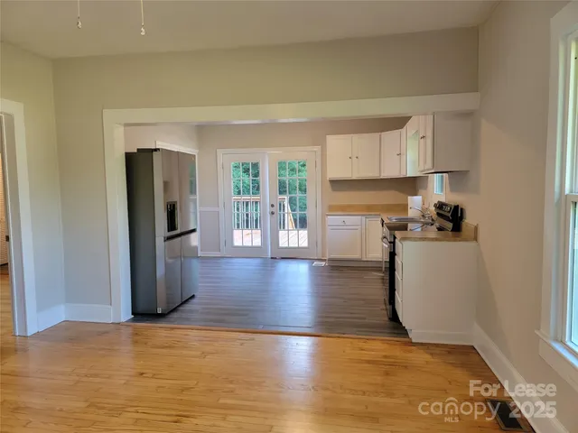 a view of a kitchen with wooden floor and a refrigerator