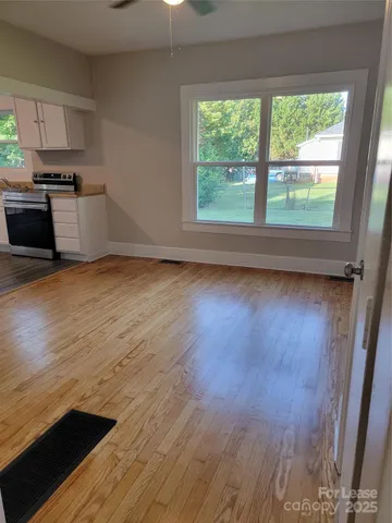 a view of a kitchen with a sink wooden floor and a window