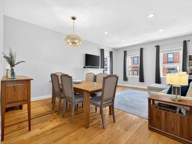 a view of a dining room with furniture a rug and wooden floor