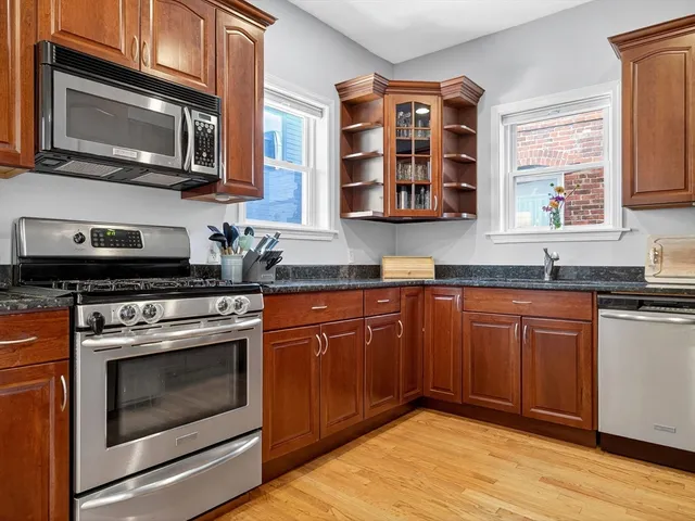 a kitchen with stainless steel appliances granite countertop a stove microwave and sink