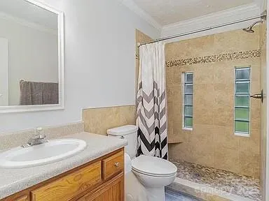 a bathroom with a granite countertop sink toilet and shower
