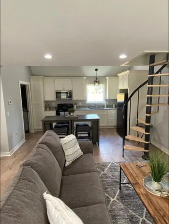 a living room with furniture and kitchen view