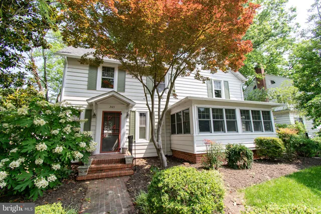 a front view of a house with yard and green space