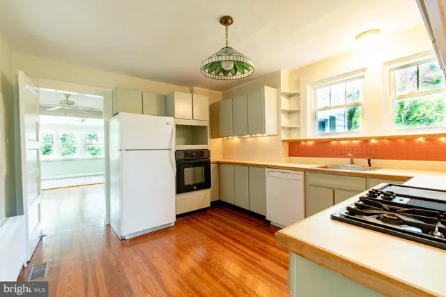 a kitchen with stainless steel appliances granite countertop a refrigerator a stove and a sink