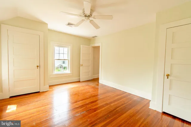 a view of an empty room with wooden floor
