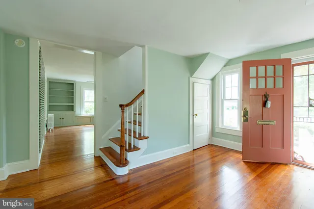 a view of an entryway with wooden floor and a livingroom
