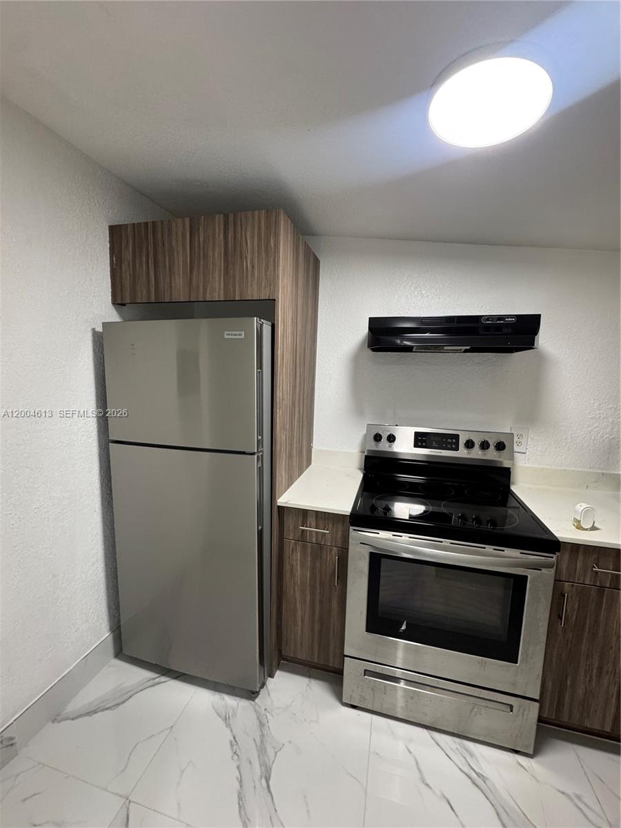 2796 Southwest 34th Court Miami, FL 33133 - Photo 6 of 8 a kitchen with a stove and a refrigerator