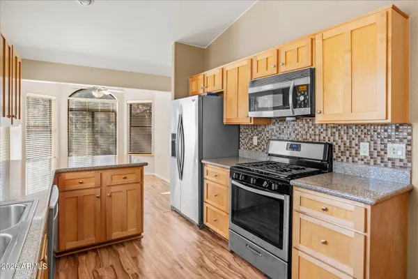 a kitchen with stainless steel appliances granite countertop a stove a sink and a refrigerator