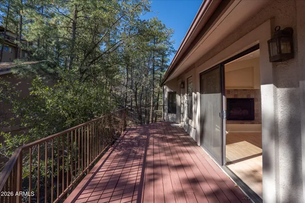 a view of a balcony with wooden floor and fence