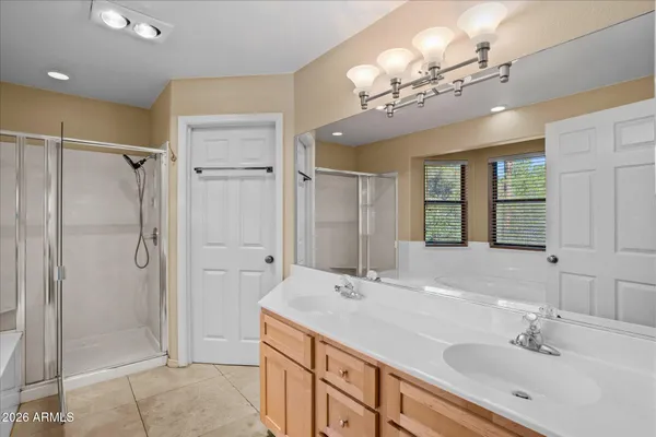 a bathroom with a double vanity sink mirror and shower