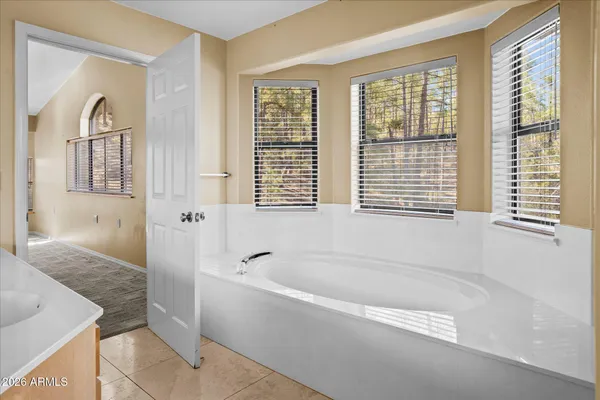 a spacious bathroom with bathtub and windows