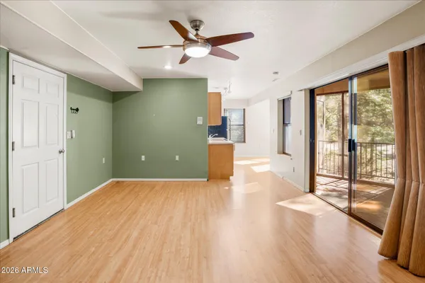 a view of a livingroom with wooden floor and a ceiling fan