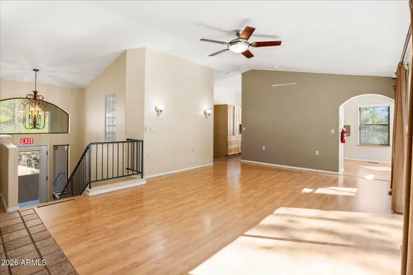 a view of a room with wooden floor and a ceiling fan