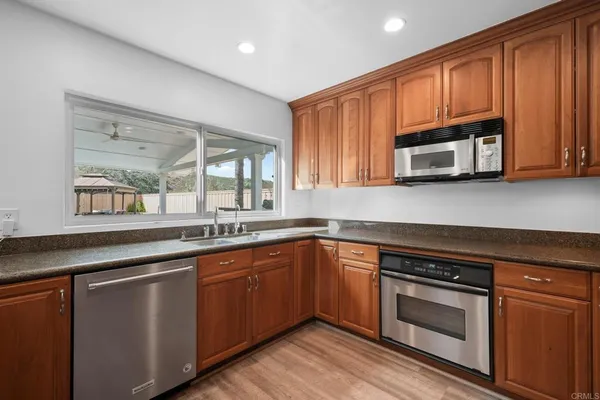 a kitchen with stainless steel appliances granite countertop wooden cabinets and a stove top oven